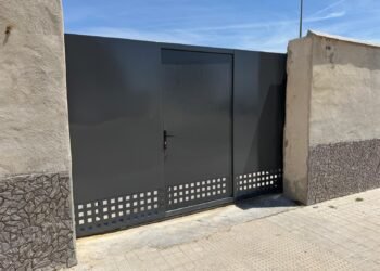 Puerta de garaje metálica automatizada con acceso peatonal integrado, fabricada e instalada por Ingemix en Valencia