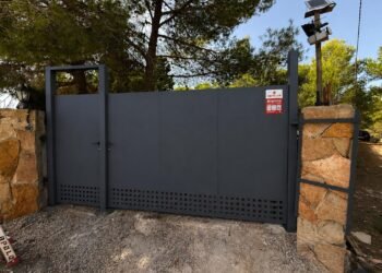 Fabricación y montaje de puerta de garaje manual a medida con acceso peatonal integrado en Valencia.